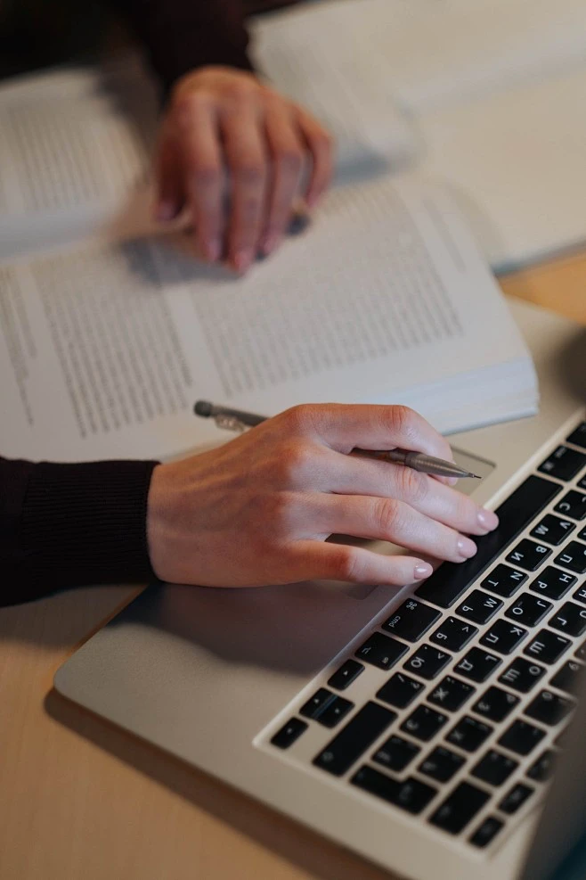 家长阅读书籍并使用电脑学习